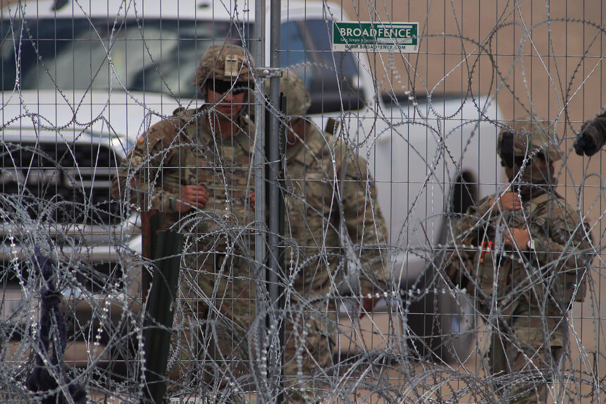 Personal de la Guardia Nacional estadounidense permanecen junto a una cerca de navajas y púas en el muro fronterizo entre México y EEUU en Ciudad Juárez, Chihuahua. Foto de EFE/ Luis Torres.