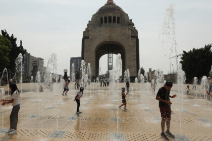 Personas juegan en una fuente del Monumento a la Revolución este domingo, en la Ciudad de México (México). Foto de EFE/ Mario Guzmán.