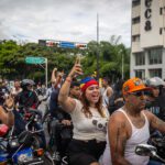 Personas recorren las calles en motocicletas durante una protesta por los resultados de las elecciones presidenciales, en Caracas, Venezuela. Foto de EFE/ Henry Chirinos.