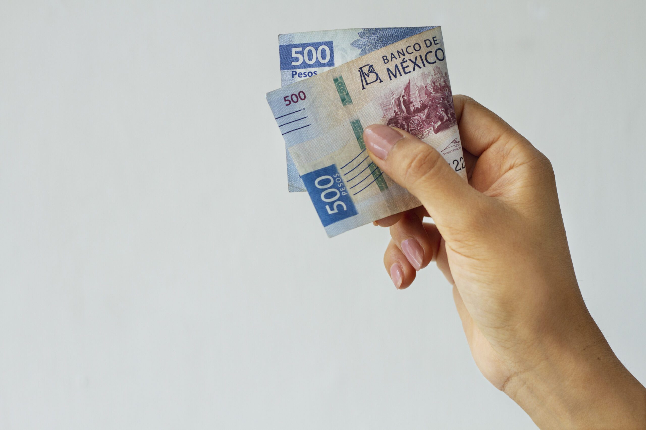 side view hand holding mexican banknote scaled