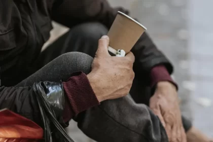 side view homeless man holding cup 1 1