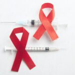 red ribbon syringe with white background hiv aids ribbon awareness