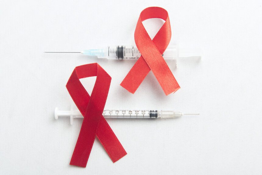 red ribbon syringe with white background hiv aids ribbon awareness