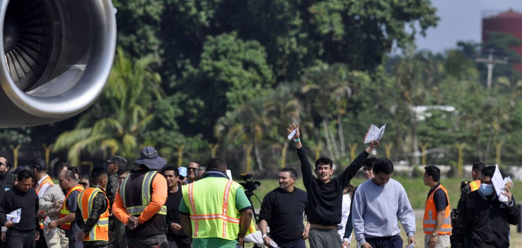 Personas deportadas llegan en un avión militar estadounidense, a la base aérea Armando Escalon ubicada en San Pedro Sula, Honduras. Foto de JLMNoticias / EFE/ Jose Valle.