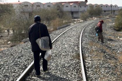 Migrantes caminan por vías de tren en Altar, Sonora. Foto de JLMNoticias / EFE/ Daniel Sánchez.
