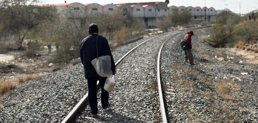 Migrantes caminan por vías de tren en Altar, Sonora. Foto de JLMNoticias / EFE/ Daniel Sánchez.