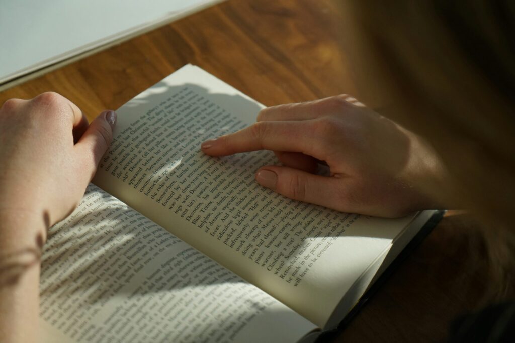 Persona leyendo un libro con el dedo señalando un párrafo, símbolo del hábito de lectura en México.