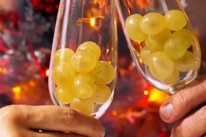 Familia mexicana come uvas durante el ritual de Año Nuevo para recibir los 12 meses