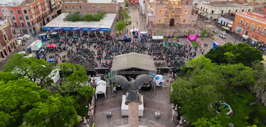 Vista aérea de la Fan Zone de Plaza Patria con cientos de aficionados siguiendo el partido México vs Corea en pantalla gigante.